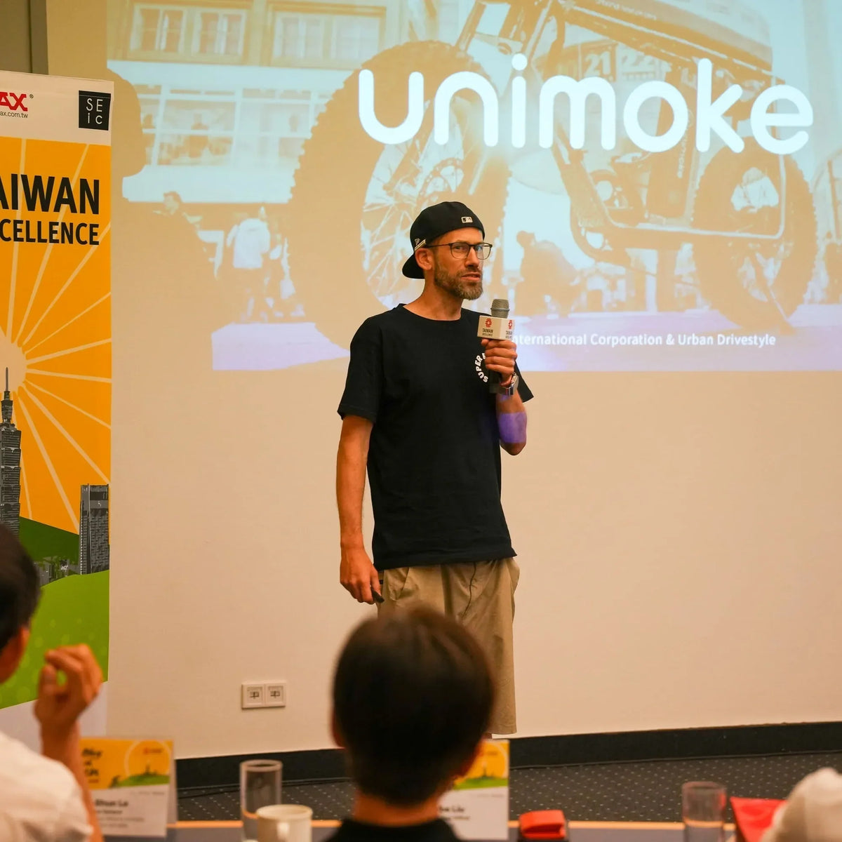 A speaker on stage presenting Unimoke, an e-bike brand from Taiwan, at the Taiwan Excellence showcase